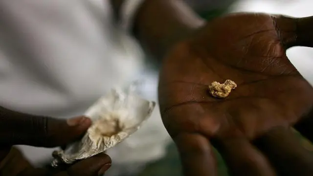 Hand holding a gold nugget