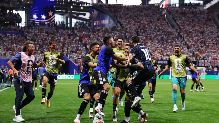 Soccer players celebrate after scoring a goal.