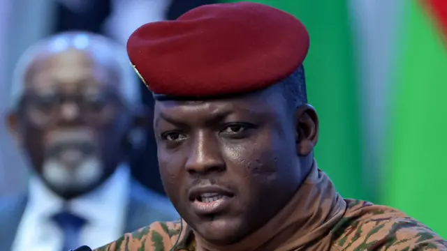 Close-up of Ibrahim Traoré in military attire, wearing a red beret and beige uniform.