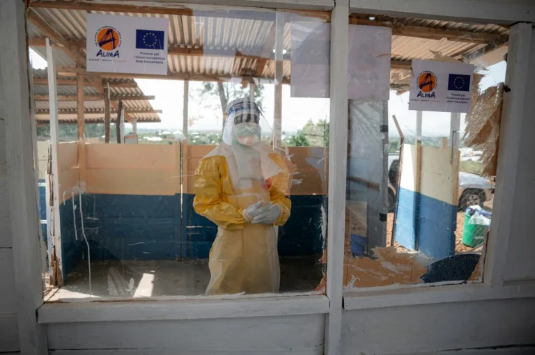 Health workers in protective gear administering Ebola vaccine in a rural clinic