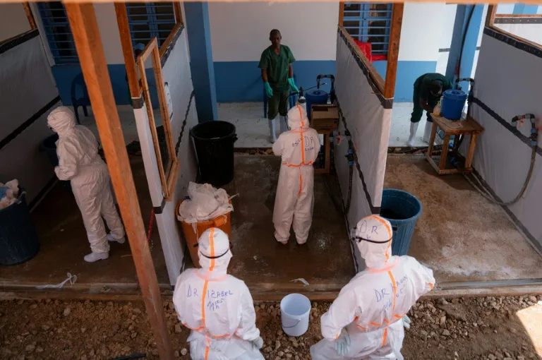 Health workers in protective gear attending to patients during an Ebola outbreak in a Congolese hospital